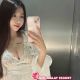Attractive young Chinese woman in a white lace top taking a selfie.