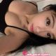 Attractive Malaysian female escort in a black top.