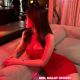 Attractive woman in red dress, hotel setting. Booking escort services.