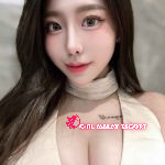 Attractive young Chinese woman in beige top.
