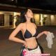 Attractive Kuala Lumpur escort in a black bikini and white pants.