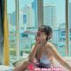 Attractive Malay woman in a light dress, relaxing by a window.